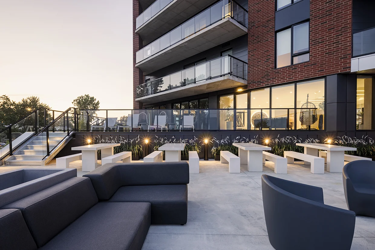 Terrasse commune avec tables et canapés extérieurs au Florent, Trois-Rivières