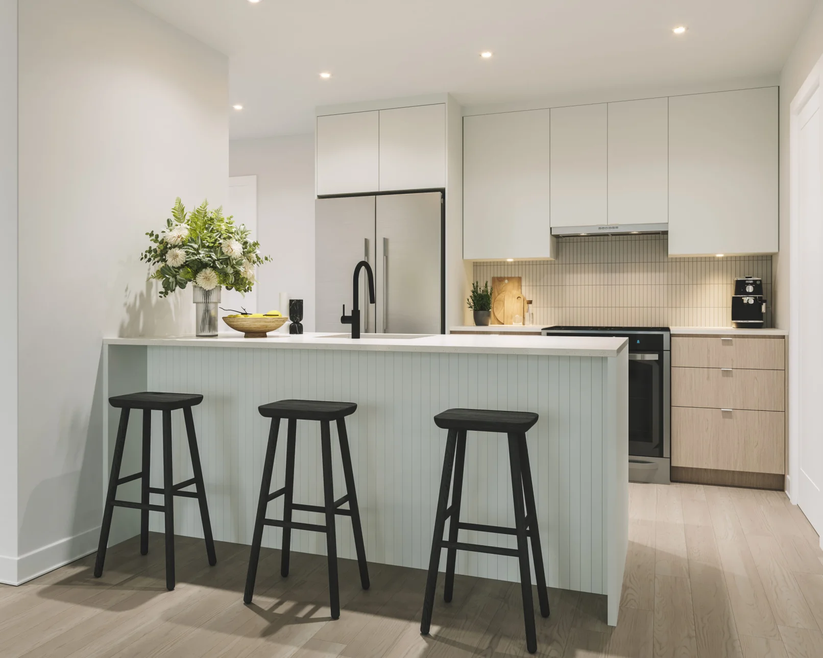 Cuisine avec îlot et tabourets dans un appartement du Florent, Trois-Rivières