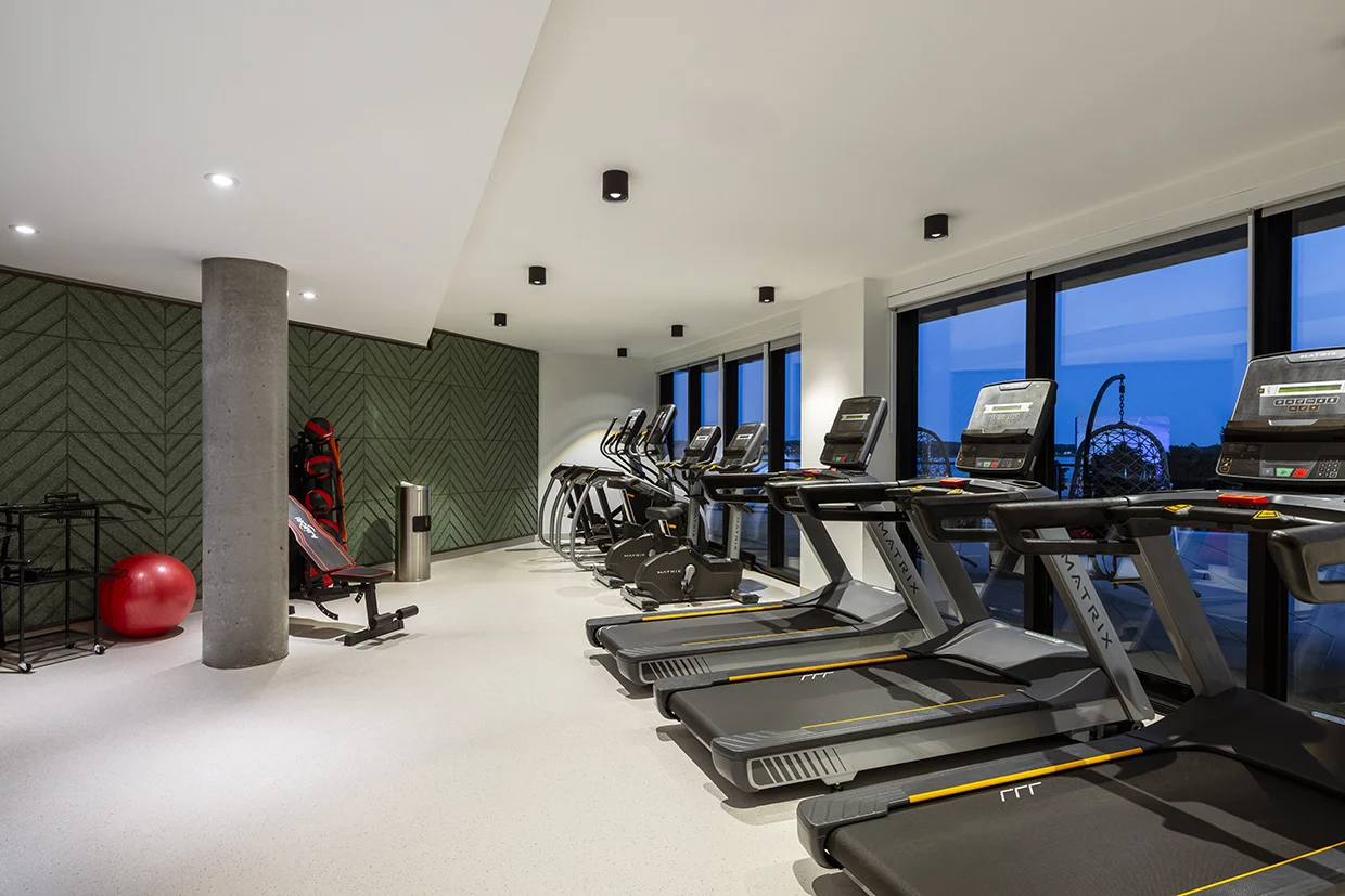 Salle d'entraînement avec tapis roulants et vue sur le fleuve au Florent, Trois-Rivières